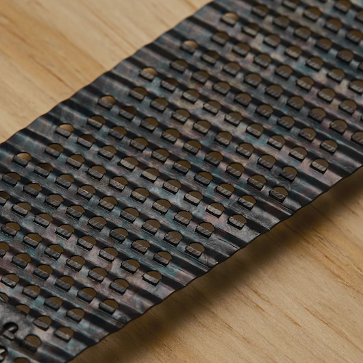 STANLEY 21-293 close-up photo of metal rasp blade surface with perforated teeth on wood background.