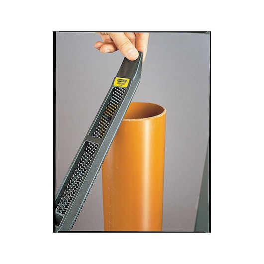 Photo of STANLEY 21-295 hand rasp being used to smooth the edge of an orange plastic pipe.