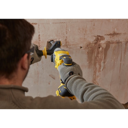 STANLEY SBH900M2K-B3 hammer drill in use on a wall, side angle, operator wearing gloves.