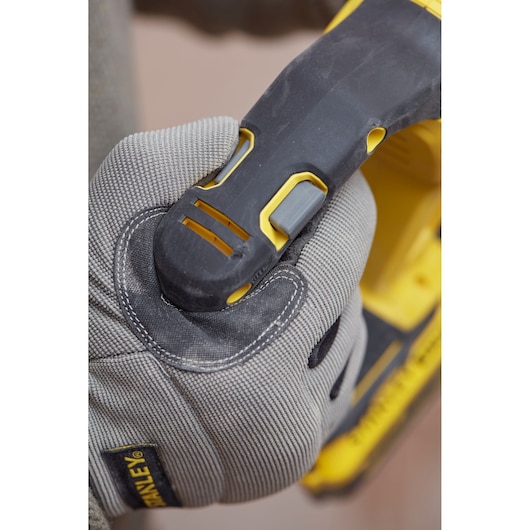 Stanley SBH900M2K-B3 power tool grip close-up, gray work glove holding black and yellow handle.