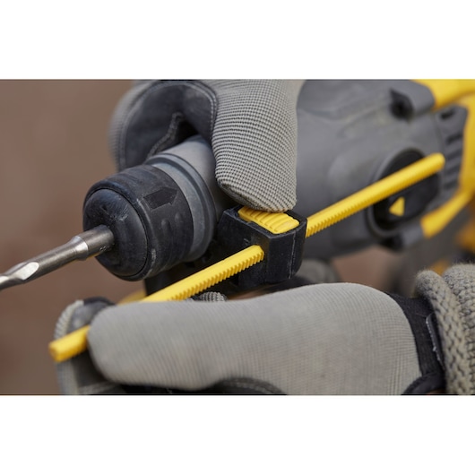 STANLEY SBH900M2K-B3 hammer drill close-up with gloved hands adjusting yellow depth gauge.