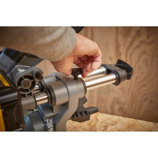 STANLEY SCM701-B3 miter saw adjustment knob close-up, hand adjusting metal rail.