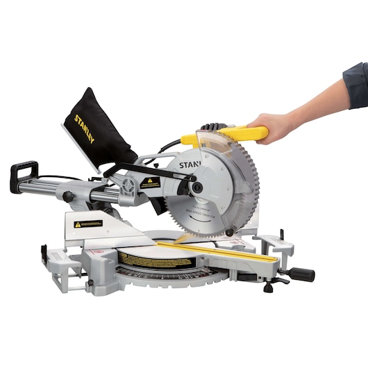 Photo of STANLEY SM18-B2C sliding compound miter saw with dust bag and yellow handle, side angle view.