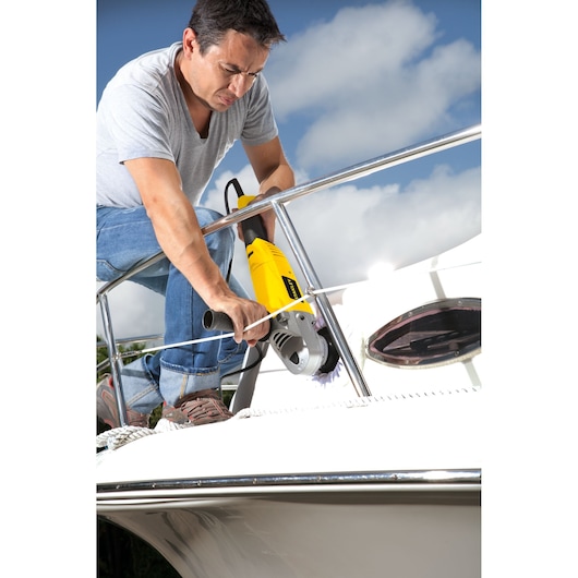STANLEY STGP1318K yellow grinder used on boat railing, outdoor scene, photography product.