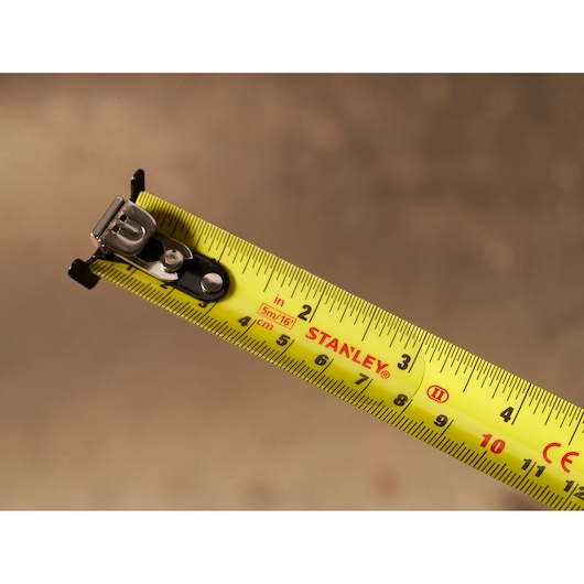 Stanley STHT37246-0 tape measure close-up showing yellow blade with metric and imperial markings.