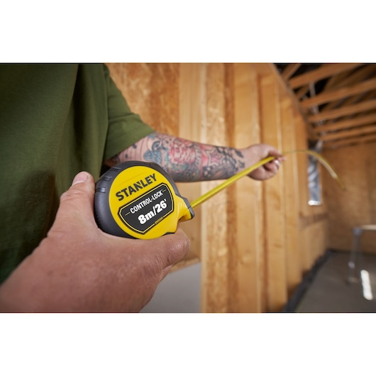 Photo of STANLEY STHT37247-0 tape measure being used to measure inside a construction site.