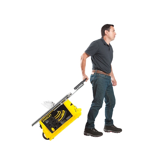 STANLEY STST1825 table saw being pulled on wheels by a person, side angle, white background.