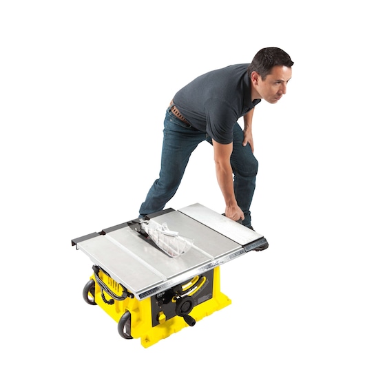 STANLEY STST1825 table saw on white background, side angle, person adjusting the saw fence.