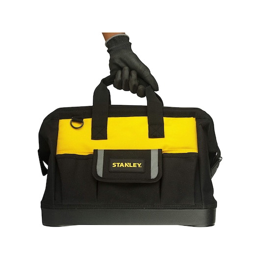 Photo of STANLEY STST516126 tool bag, black and yellow, front view, carried by a gloved hand.