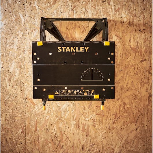 STANLEY STST83800-1 folding workbench with black surface, yellow accents, and measurement markings, front view.
